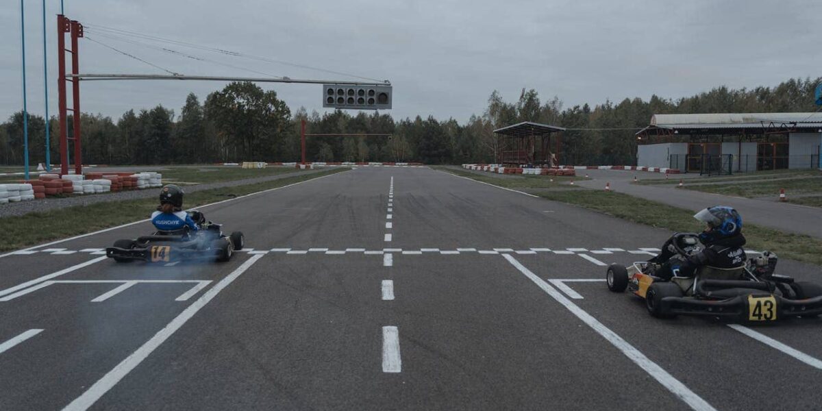 Zwei Karts fahren schnell durch eine Kurve auf einer Indoor-Kartbahn
