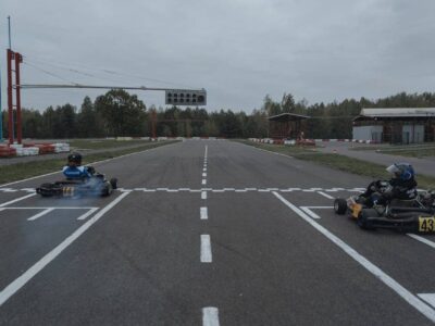 Zwei Karts fahren schnell durch eine Kurve auf einer Indoor-Kartbahn
