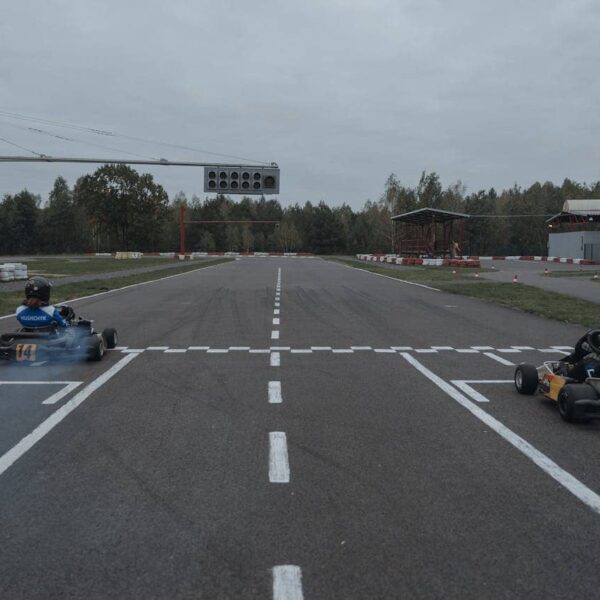 Zwei Karts fahren schnell durch eine Kurve auf einer Indoor-Kartbahn