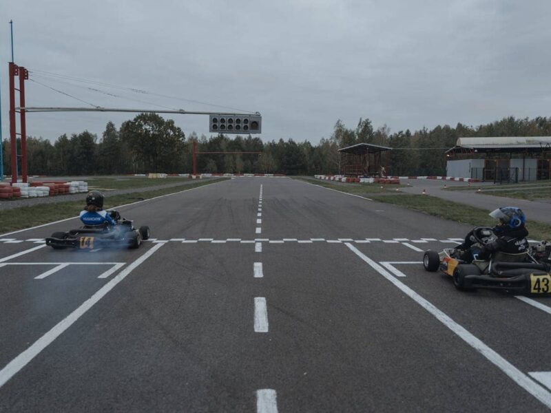 Zwei Karts fahren schnell durch eine Kurve auf einer Indoor-Kartbahn