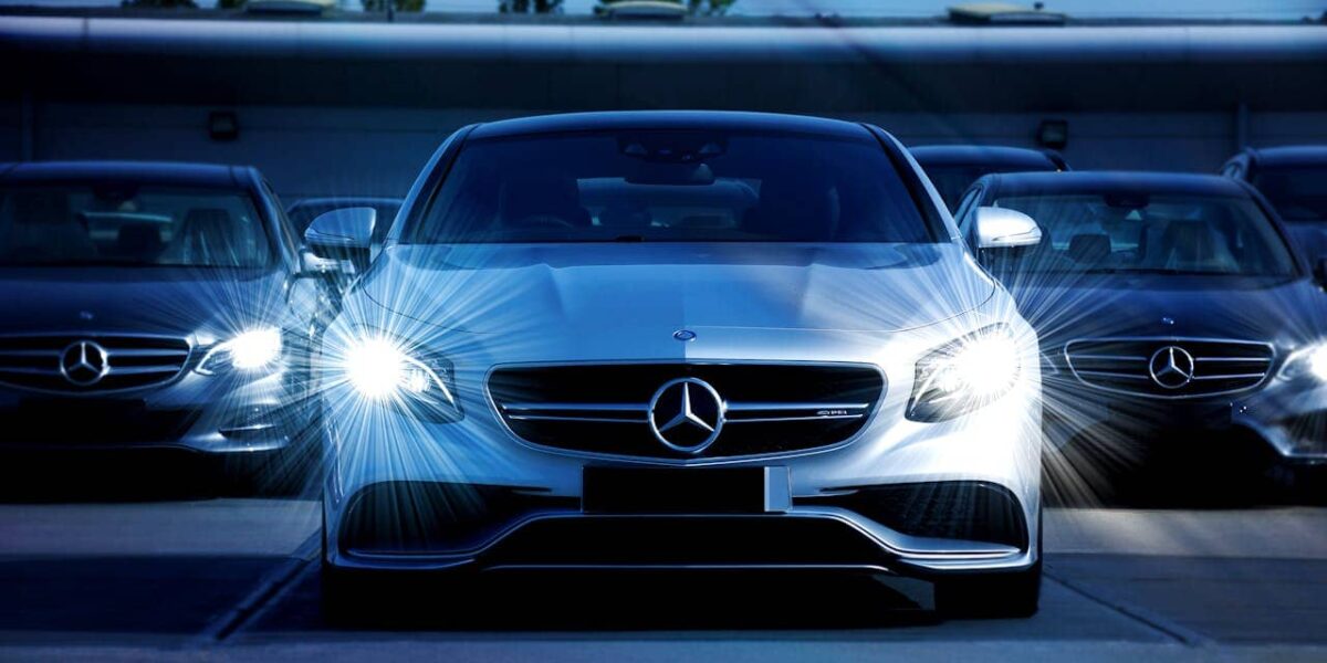Mercedes-Benz Limousine im Vordergrund, moderne Glasfassade im Hintergrund