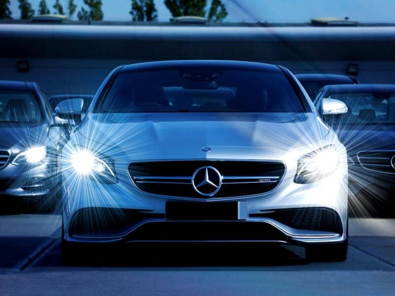 Mercedes-Benz Limousine im Vordergrund, moderne Glasfassade im Hintergrund