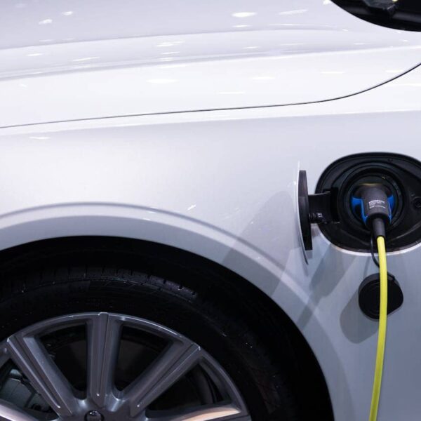 Nahaufnahme eines Kfz-Mechanikers beim Reparieren eines Elektroautos in einer Werkstatt