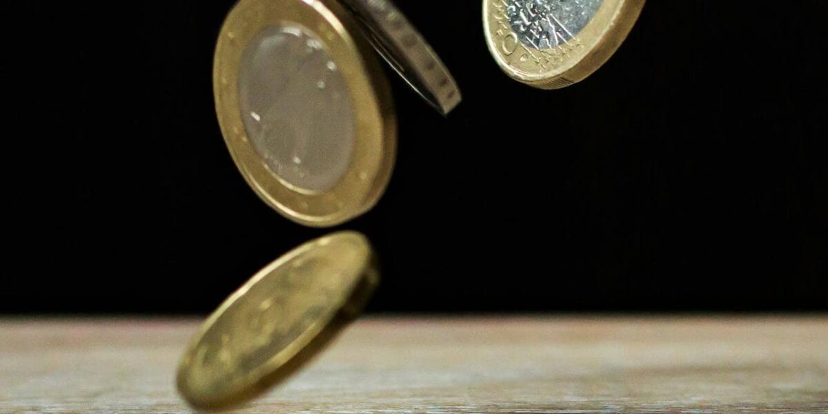 einige eurobanknoten und münzen auf einer tischoberfläche vor auto