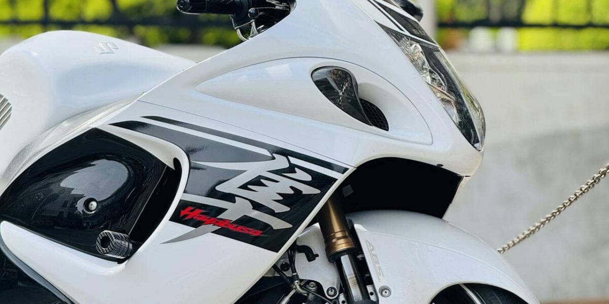 Person fährt Motorrad durch Den Haag bei sonnigem Wetter, Stadtverkehr im Hintergrund