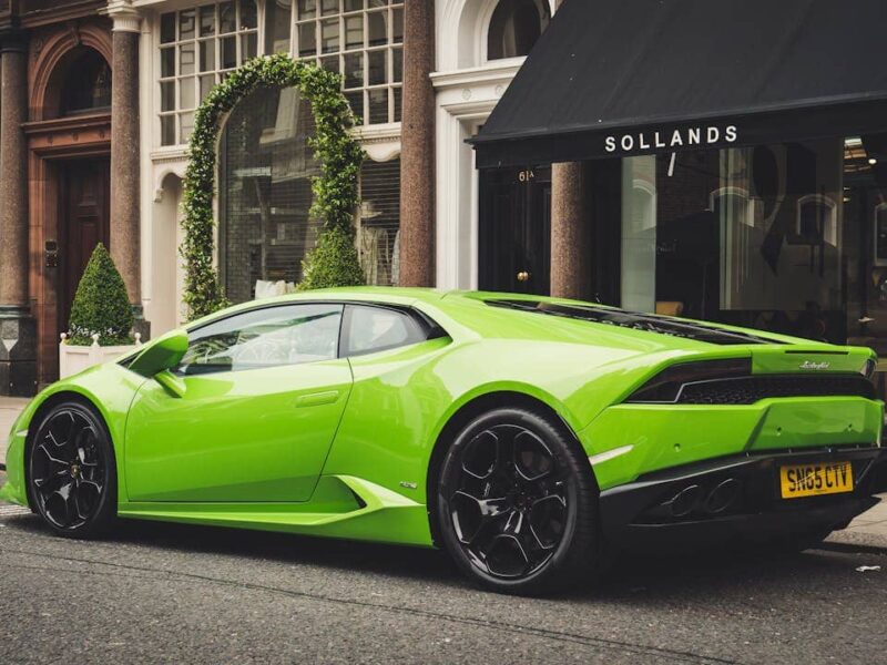 Lamborghini auf einer Straße in Dubai bei Sonnenuntergang, mit Skyline im Hintergrund
