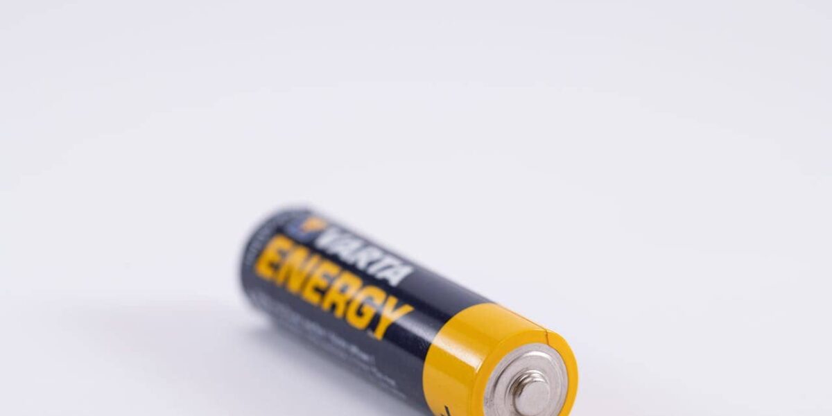 Nahaufnahme eines Autoschlüssels mit ausgebauter Knopfzellenbatterie auf einem neutralen Hintergrund