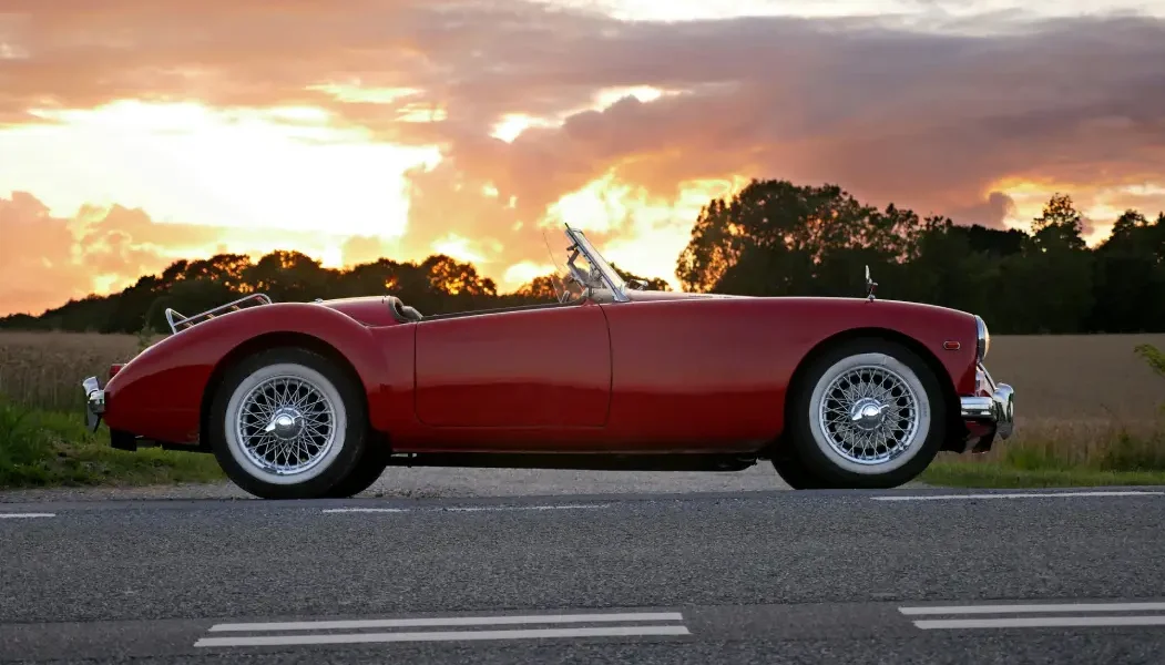 Ein rotes Cabrio bei Sonnenschein auf einer Landstraße