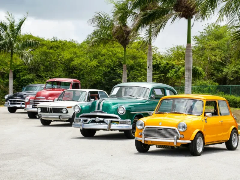Eine Reihe von Oldtimern auf einem Parkplatz geparkt