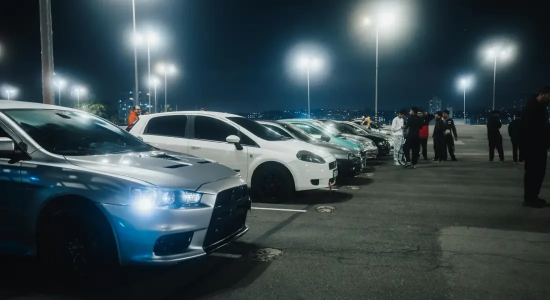 Autos geparkt auf einem Parkplatz bei Nacht.