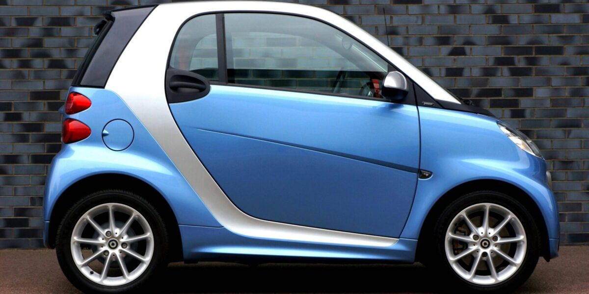 weißer mitsubishi space star, citroën c1, fiat panda, toyota aygo und fiat 500 auf einer straße im sonnenlicht