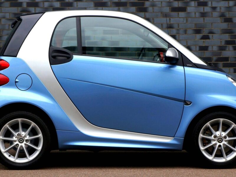weißer mitsubishi space star, citroën c1, fiat panda, toyota aygo und fiat 500 auf einer straße im sonnenlicht