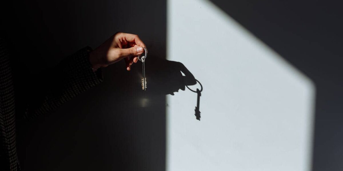 Mann steht entspannt neben einem neuen Opel und genießt die Sonne auf einem Parkplatz